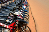 Ouagadougou, Burkina Faso: parked motorbikes and asphalt covered in red dust - photo by M.Torres