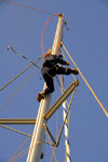 Palmeira, Sal island / Ilha do Sal - Cape Verde / Cabo Verde: yacht captain going up alongside the mast - photo by E.Petitalot