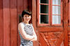 Odense, Funen island, Syddanmark, Denmark: smiling young woman posing in front of an old timber framed house - photo by K.Gapys