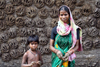 India - West Bengal: a woman uses her hands to place cow dung on a wall - photo by M.Wright