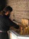 Montenegro - Crna Gora - Cetinje - old capital of Montenegro: inside the Bogorodicin Orthodox Monastery / Bogorodicin monastyr - monk and candles - photo by J.Kaman