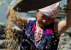 Nepal - Langtang region - woman using wind to separate grain and dust - photo by E.Petitalot