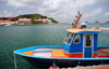 Gustavia, St. Barts / Saint-Barthlemy: blue boat in the harbour - Fort Oscar, museum and Htel de la Collectivit  in the background - photo by M.Torres