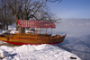 Slovenia - View across to the island church on Lake Bled when frozen over in winter with Pletna boat moored in front - Blejsko jezero - photo by I.Middleton