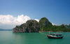 Halong Bay - vietnam: fishing boat and rock formation covered in dense vegetation - photo by Tran Thai